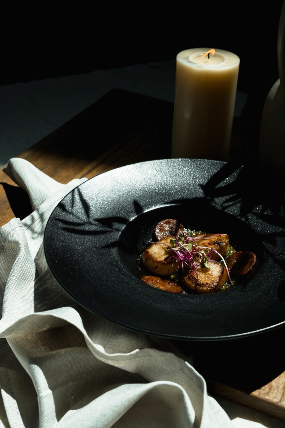 Fine-Dining-Gericht im Kerzenlicht auf dunklem Teller – Chez Porteur, Jonas Träger